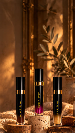 Les trois huiles à lèvres Secrets d'Autrefois, Marron Glacé, Rose et Nacrée, dans un décor cocooning à la lueur d'une bougie